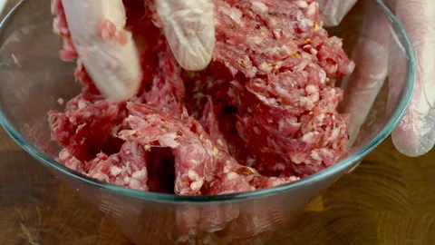 Chef hands in transparent gloves mix minced meat with spices in glass bowl. Stock Footage 234807819