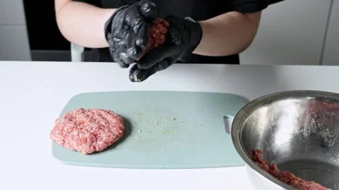 Chef hands wearing black gloves skillfully shaping raw ground beef into bur.. Video stock 322598841