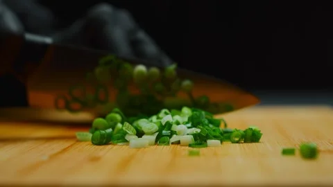Chef hands wearing gloves chopping green onions on wooden board Stock Footage 319744917