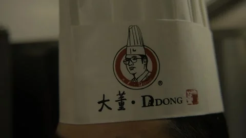 Chef Hat With Illustrated Logo in Beijing Restaurant Kitchen Close-Up Stock Footage 345763376