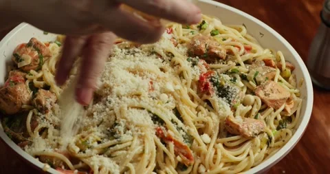 Chef he cook stirs the spaghetti with cherry tomato slices and spinach in creamy Vídeo Stock 327974444