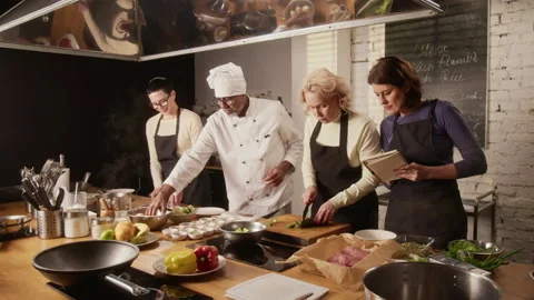 Chef Helping Group of Women During Cooking Master Class in Restaurant Stock Footage 332569732