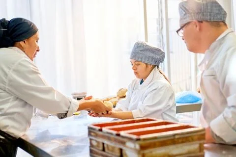 Chef helping students with Down Syndrome in baking class Stock Photos