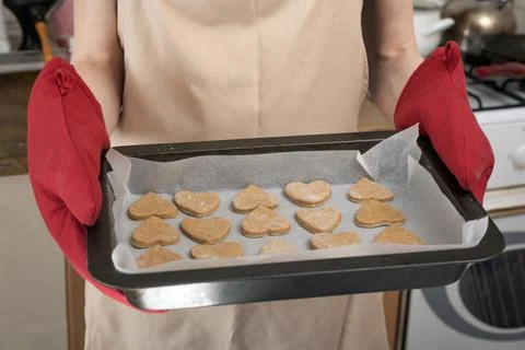 Chef is holding baking sheet with raw shortbread cookies. Cookies making proc Stockfoto's