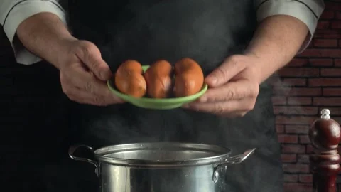 Chef holding green plate with cooked sausages over hot pan in kitchen, rustic Stock Footage 339366874