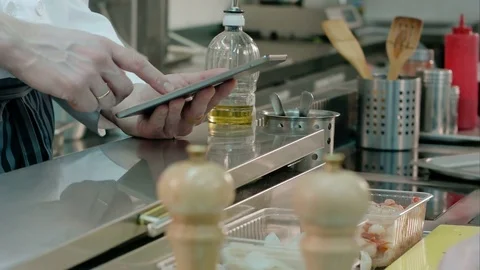 Chef holding tablet while cook putting champignons on a frying pan Vídeo Stock 72326579