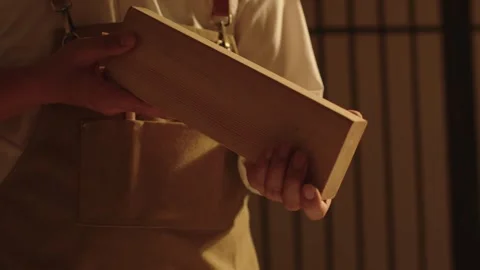 Chef Holding Wooden Block in Warm Kitchen Interior Stock Footage 337415331