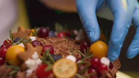 Chef holds a hand with fruit decorates a kumquat cake Stock Footage 119856959