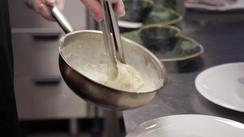 Chef impose cooked pasta to white plate in kitchen restaurant or cafe. Stock Footage 76626631