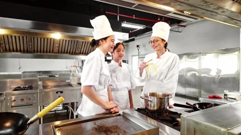 Chef instructor and two students tasting freshly cooked pasta in a kitchen. Stock-Footage 312192930
