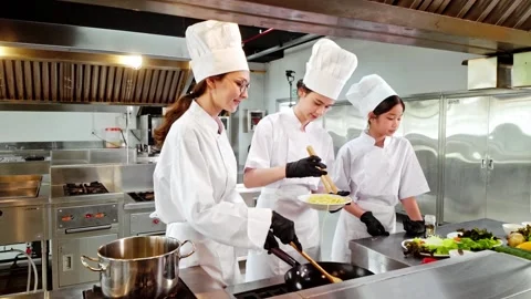 Chef instructor and two students tasting freshly cooked pasta in a kitchen Video stock 320862698