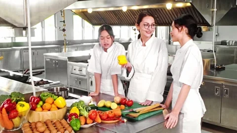 Chef instructor teaching two young culinary students in a commercial kitchen. Stock-Footage 312192934