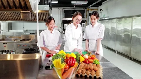 Chef instructor teaching two young culinary students in a commercial kitche.. Stock Footage 323065891