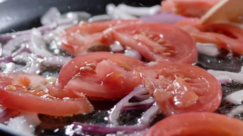 Chef interferes chopped tomatoe and onion slices by wooden spatula. Close-up of Stock Footage 151794108