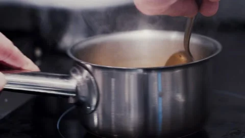 The chef interferes with a spoon in the pan dish Vídeo Stock 158982097