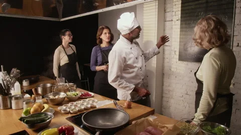 Chef Introducing Group of Women to Plan at Cooking Master Class in Restaurant Stock Footage 332572295