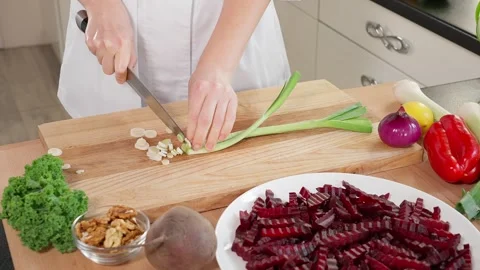 The chef in the kitchen  chops leeks on a wooden board Stock Footage 265177145