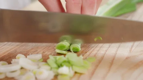The chef in the kitchen chops leeks on a wooden board Stock Footage 265177166