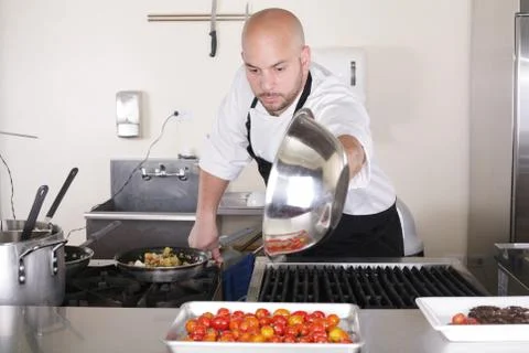 Chef in kitchen cooking, he is working on the sauce for the food Stock Photos