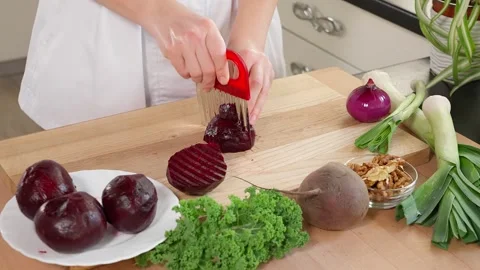 The chef in the kitchen cuts boiled beets with a figured knife Stock Footage 265177020