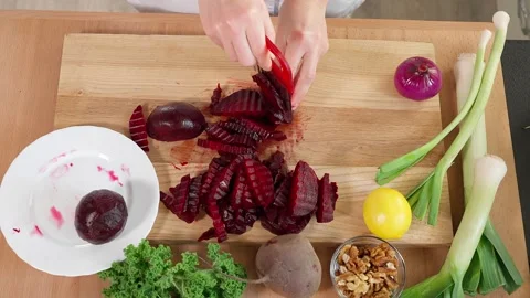 The chef in the kitchen cuts boiled beets with a figured knife Stock Footage 265177046