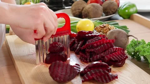The chef in the kitchen cuts boiled beets with a figured knife Stock Footage 265177066