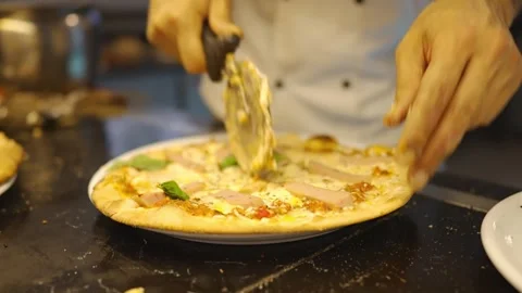 The chef is in the kitchen cutting freshly made pizza with a knife Stock Footage 276419603