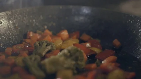 Chef in a kitchen making flambe with vegetables Stock Footage 70383507