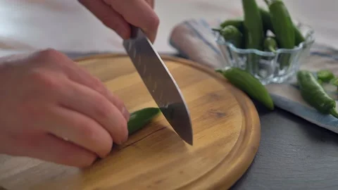 Chef in kitchen mixing and mincing cilantro, red onion, and a jalapeno for Stock Footage 135310784
