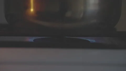 Chef in kitchen placing pot on stove and igniting burner Stock Footage 292389273