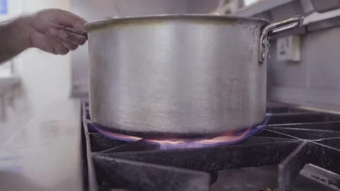 Chef Kitchen Pot Stirring on Stove top fire Stock Footage 143788666