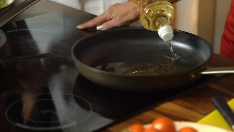 Chef in kitchen pours plenty of sunflower oil on a frying pan for frying dishes Stock Footage 130000183