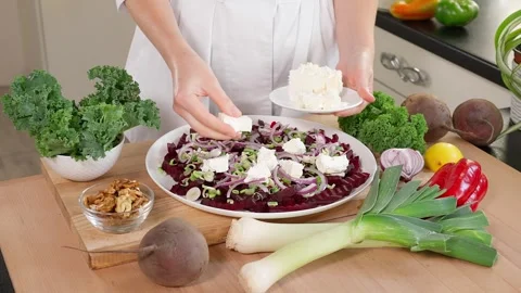 The chef in the kitchen prepares a healthy beet salad, puts feta cheese Stock Footage 265177211
