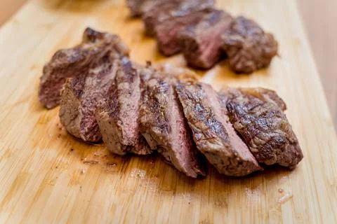 Chef at the kitchen preparing beef steaks on the home electric grill Stock Photos