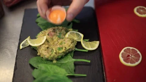 The chef in the kitchen preparing carpaccio with egg Stock Footage 83587405