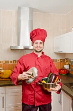 Chef in kitchen preparing food Stock Photos