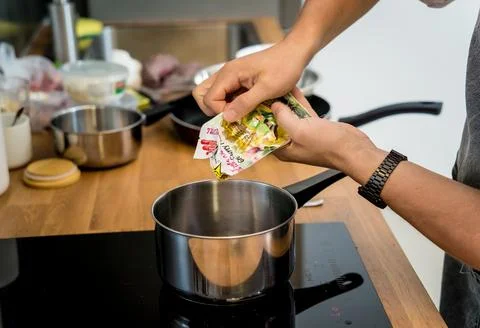 Chef at the kitchen preparing green curry with herbs and rice Stock Photos