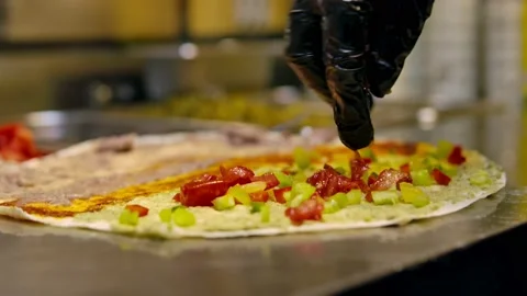 Chef in the kitchen puts the Mexican taco tortilla with tongs.  Chef cooking del Stock Footage 155210222
