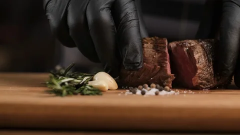 Chef in the kitchen at the restaurant shows roast beef. roast beef cut 库存影片 106932645