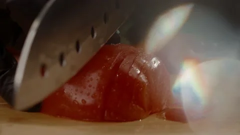 Chef in the kitchen slices the tomato with a sharp steel knife. Slow motion 4K Stock Footage 168821628