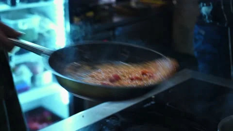 The chef in the kitchen tosses the dish up, mixes it up. Steam, cooking smoke Stock Footage 141413408