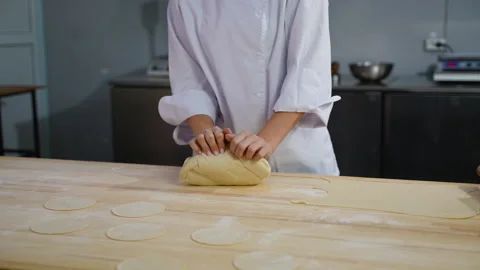 Chef kneading dough with flat circles on wooden table Stock Footage 299654323