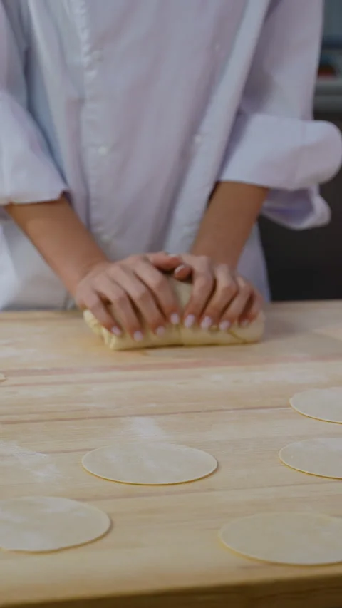 Chef kneading dough with prepared flat circles on table Video stock 299665424