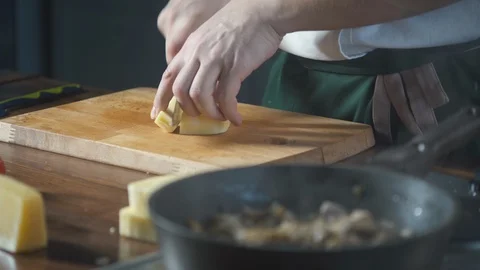 Chef with a knife cuts cheese on a cutting board. Food on cuisine. Making meal. Stock-Footage 124753822