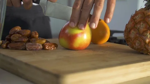 Chef with knife cutting apple on chopping board in kitchen Stock Footage 85814723
