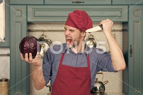Chef with knife shout at purple cabbage. Angry man in red hat and apron in Stock Photos