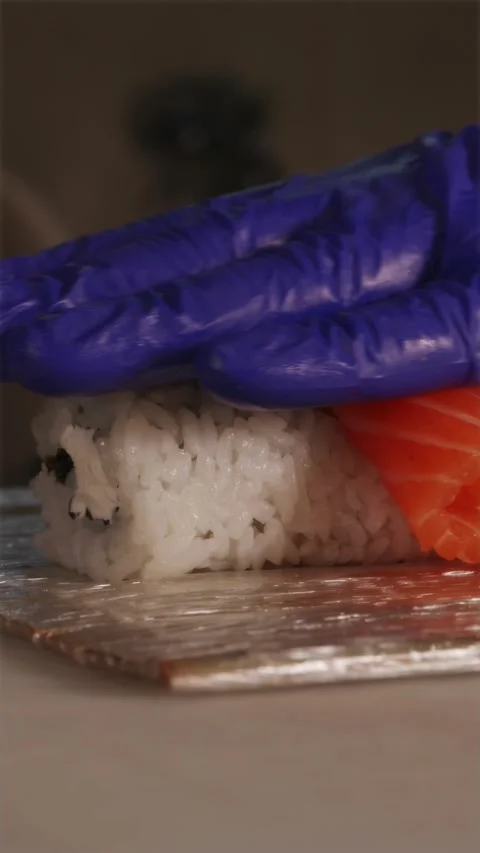 Chef layering fresh orange salmon slices over sushi roll base 스톡 동영상 337119128
