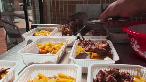 The chef lays out the cooked meat in plastic containers with Uzbek pilaf Stock Footage 263100606