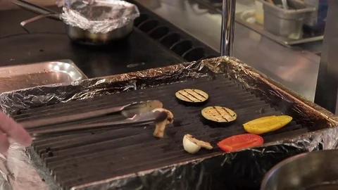 Chef lays out vegetables from baking tray grill in big modern restaurant Stock Footage 77415971