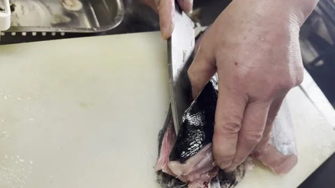 Chef lifting a freshly cut fillet of young bluefin tuna from the cutting board Stock-Footage 338148911